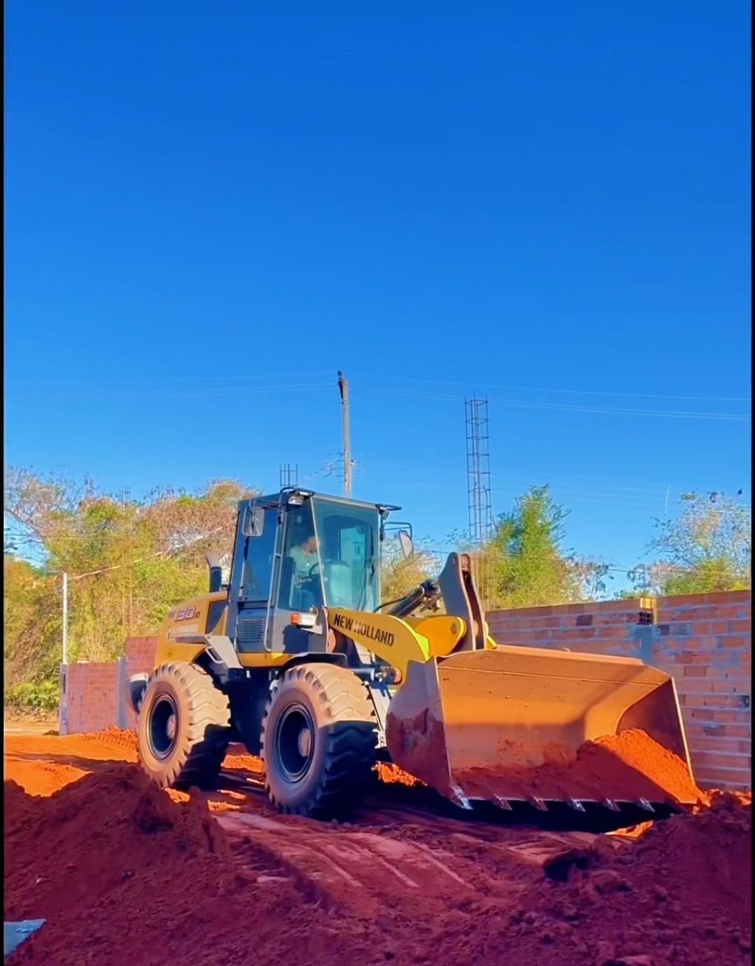 Pá carregadeira New Holland da VGiraldes movimentando terra em obra